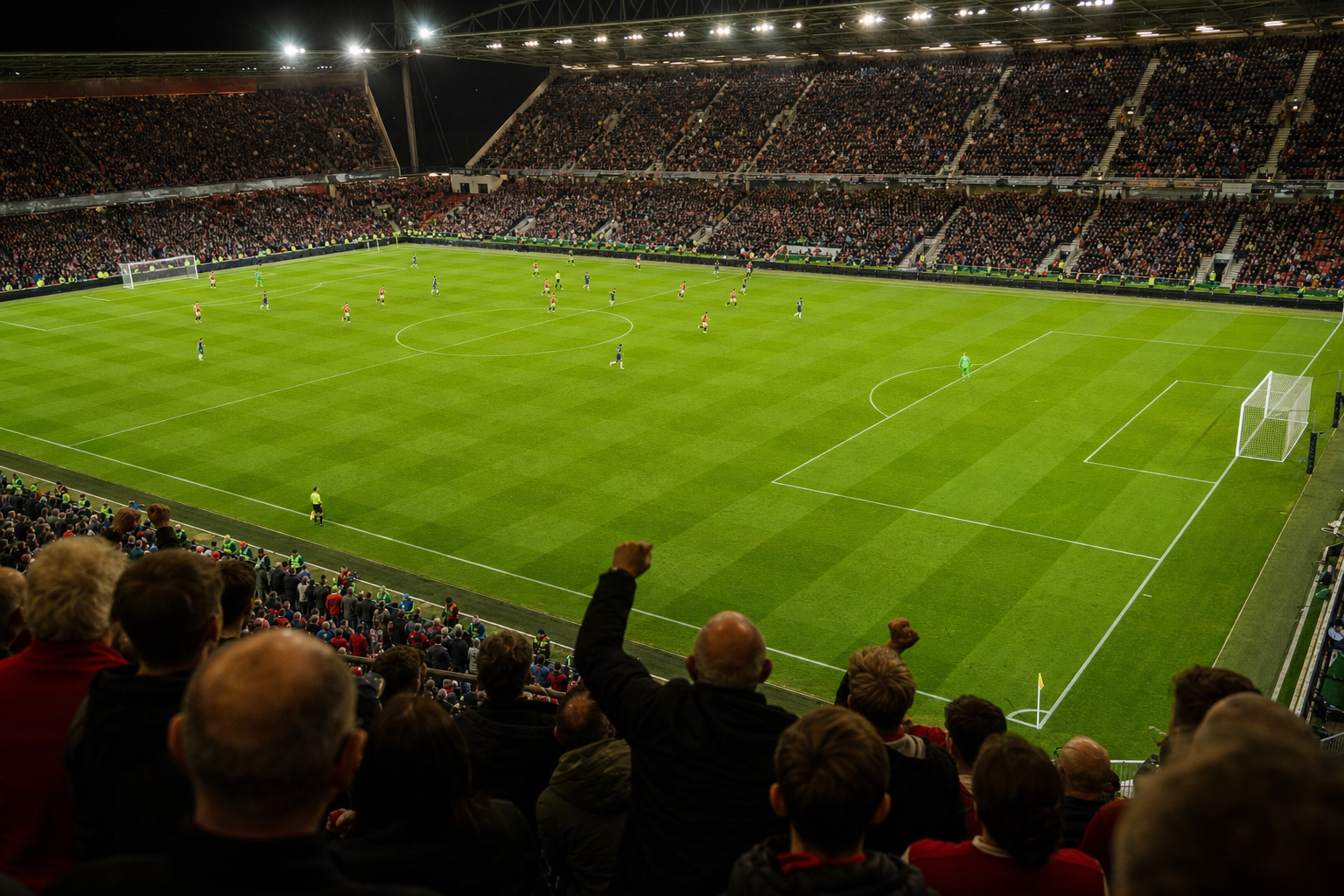 An English Premier League stadium under floodlights with a packed crowd